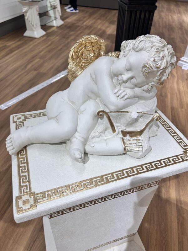 Figur eines Engels, der auf einem Baumstamm mit Schleife schläft. 24 cm.